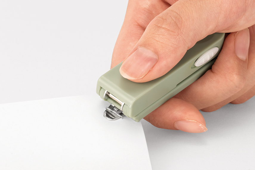 ステープラの裏面にあるリムーバーで、針を取り外そうとしている様子。