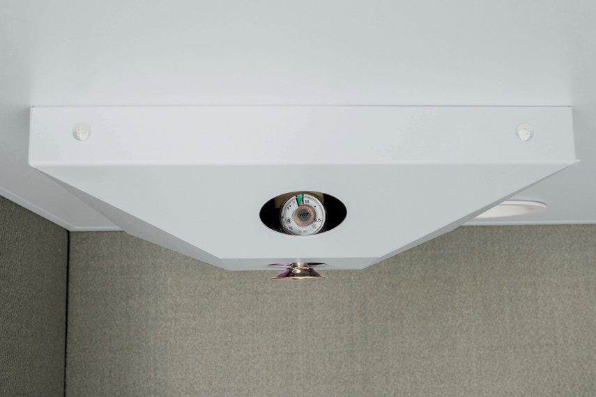 ブース内天井に設置された熱感知式の消火装置にフォーカスした画像。