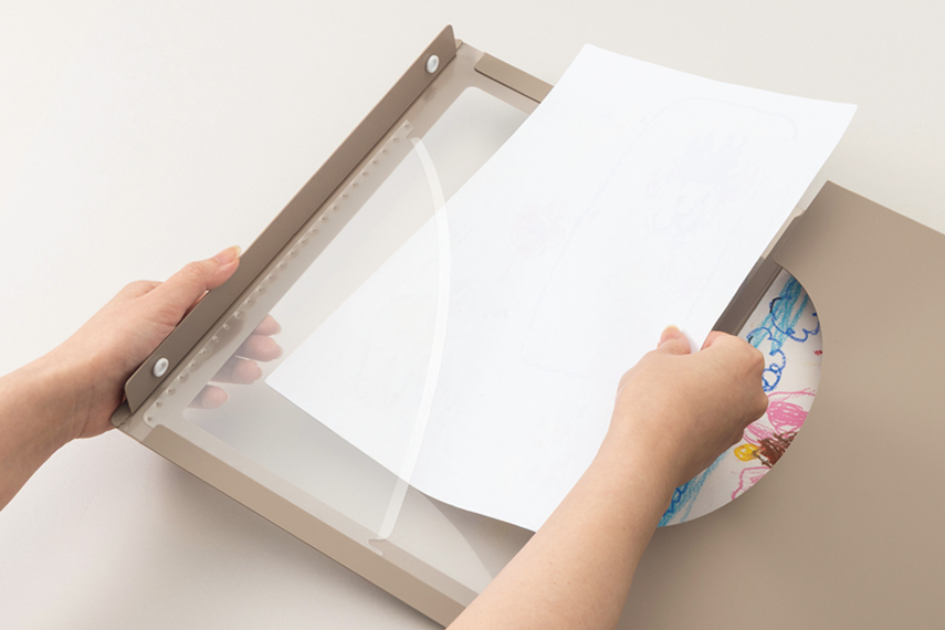 フレームホルダーの「前面ポケット」に作品を入れている様子の画像。