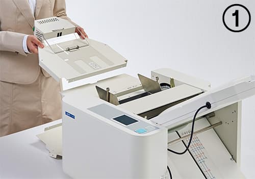 ①エアーさばきユニットを紙折機本体の給紙テーブル(排出口側)に装着します。