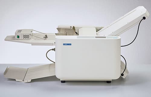 紙折機にエアーさばきユニットを装着し、横からみた状態。