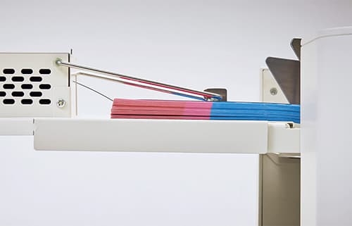 コート紙の束を紙折機にセットしただけでは、用紙同士が密着してしまっています。